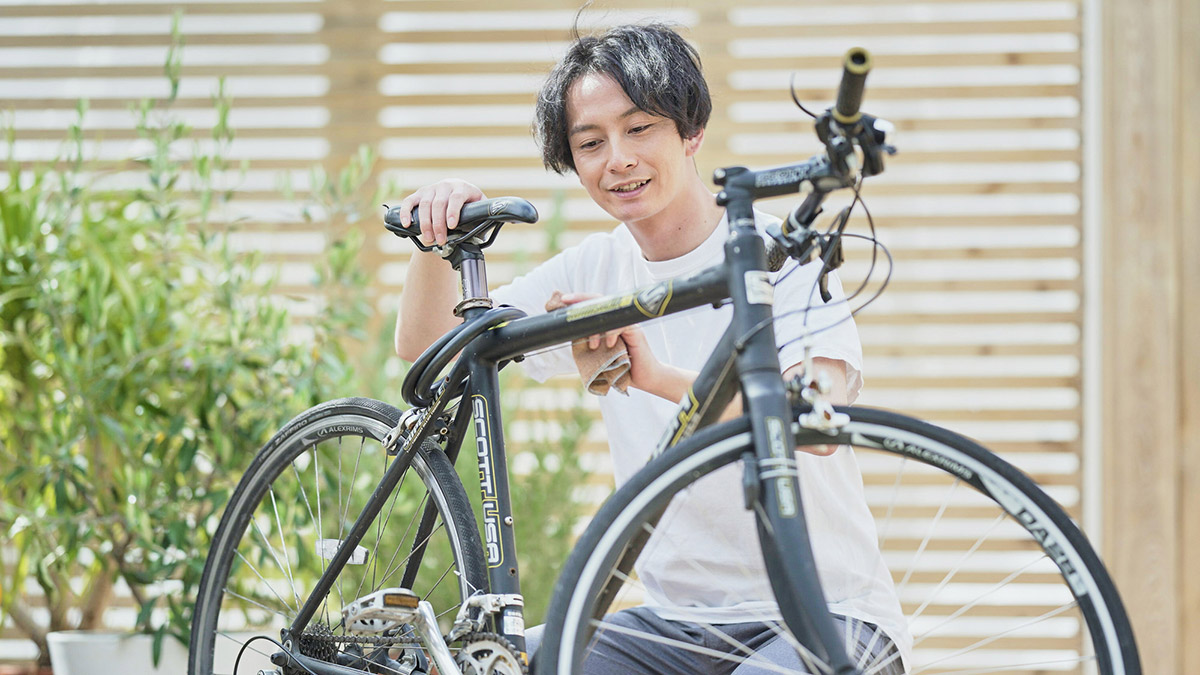 自転車の水分を布で除去する男性